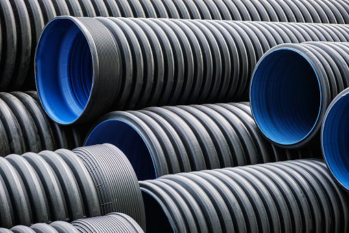 Close-up of a lot of large plastic corrugated pipes for water supply. Reconstruction of the pipeline and sewerage in the city.