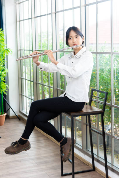 flute classical instrument profestional player playing song.  a young and elegant asian woman plays the flute. - flute solo imagens e fotografias de stock