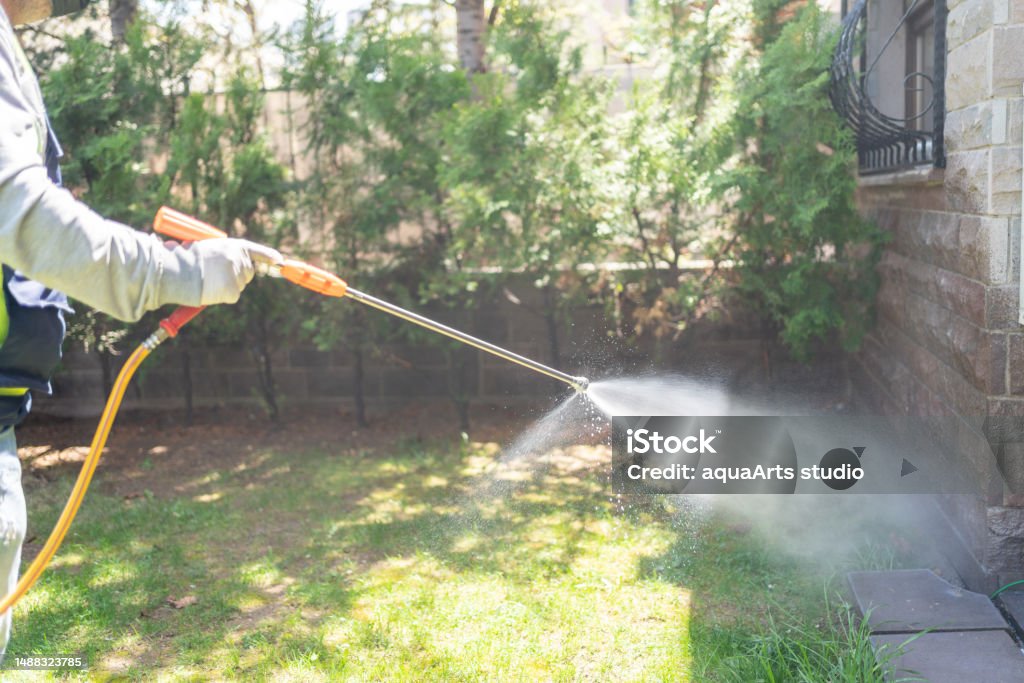 Doing Pest Control Outside House Pest Control Man Spraying Pesticide In Garden Pest Control Stock Photo