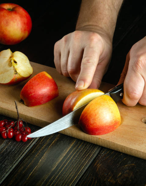istock The chef cuts apples on a cutting board to make compote or fruit juice. Apple diet for a set of vitamins. Work environment on the kitchen table 1488325211