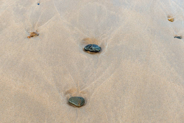 small pebbles in the surf area of the sea, which are slightly sunken in the sand