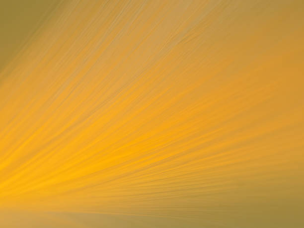 close-up optical fibers of a fiber optic lamp that glows yellow.