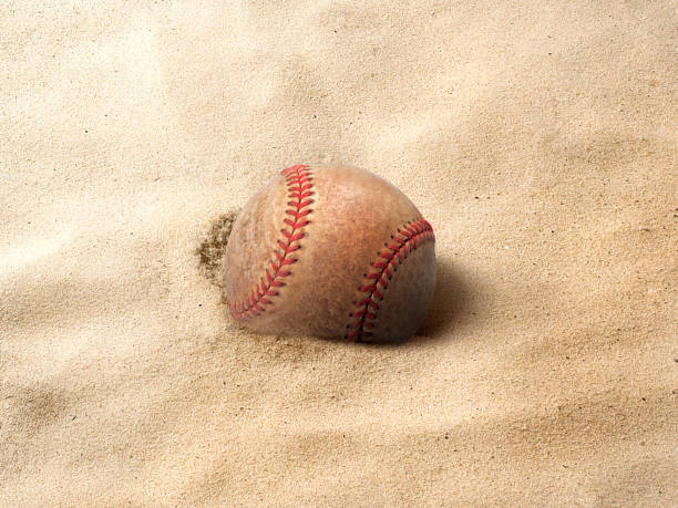 istock baseball ball on the sand background 1488326842