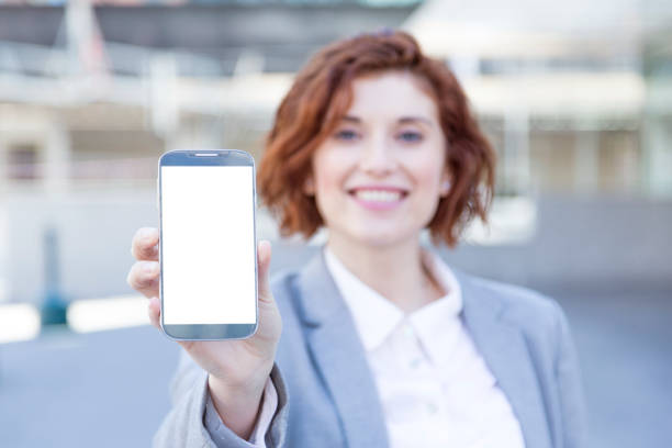istock red-haired woman holding a cell phone with empty cell phone screen 1488327754