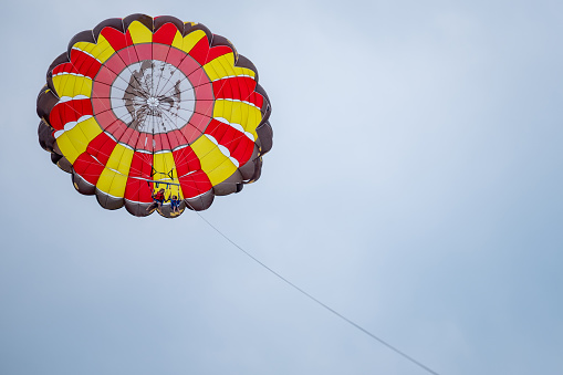 Wide shot of mother and son parasailing during summer day at sea