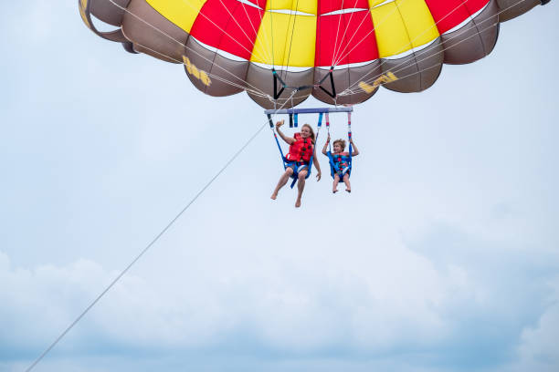 istock Mother and son parasailing during summer day at sea 1488331645