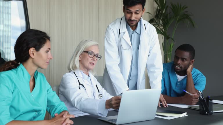 Medical employees, professional working together in conference room using laptop