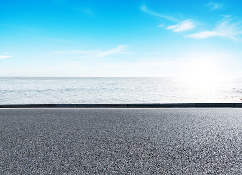Side view of empty asphalt road and beautiful sea landscape