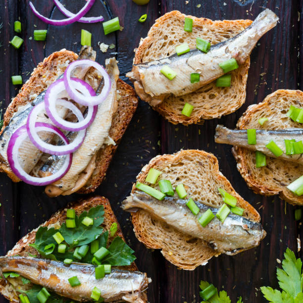 istock sandwich with sardines, sprinkle with onions on a black background closeup 1488333479