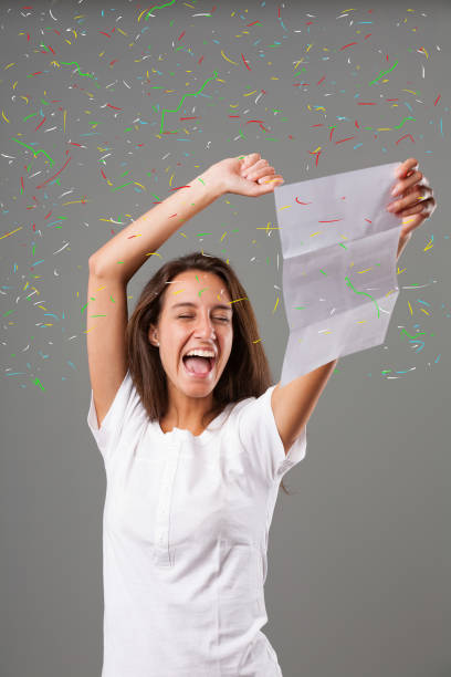 istock Joyful young woman with paper 1488333498