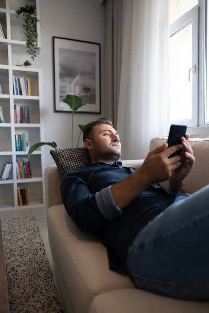 istock Thoughtful serious man sitting on sofa at home, lost in thoughts 1488334535