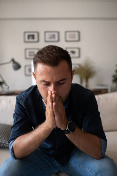 istock Thoughtful serious man sitting on sofa at home, lost in thoughts 1488334602