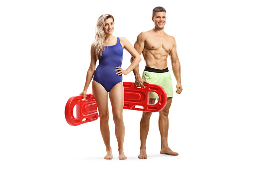 Attractive man and woman in swimwear holding swimming floats isolated on white background