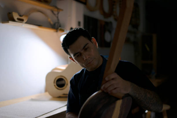 Guitar maker is making guitar at workshop. Guitar maker is making guitar at workshop. Custom guitar and small business concept. acoustic guitar tattoos stock pictures, royalty-free photos & images