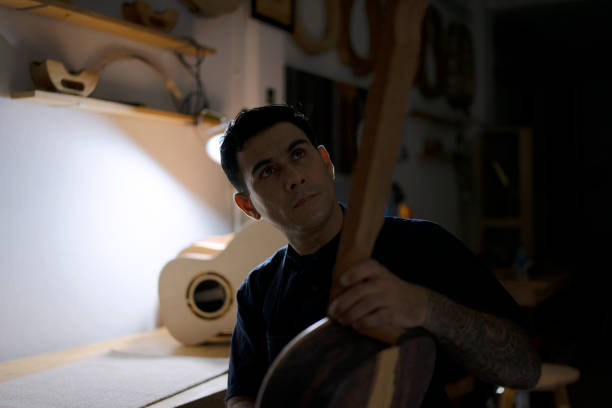 Guitar maker is making guitar at workshop. Guitar maker is making guitar at workshop. Custom guitar and small business concept. acoustic guitar tattoos stock pictures, royalty-free photos & images