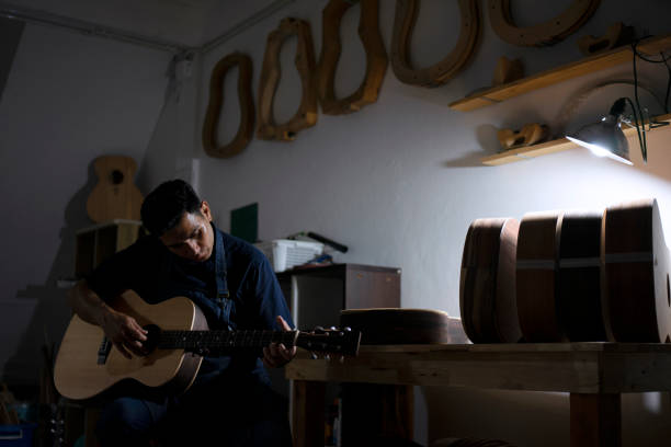 Guitar maker is making guitar at workshop. Guitar maker is making guitar at workshop. Custom guitar and small business concept. acoustic guitar tattoos stock pictures, royalty-free photos & images