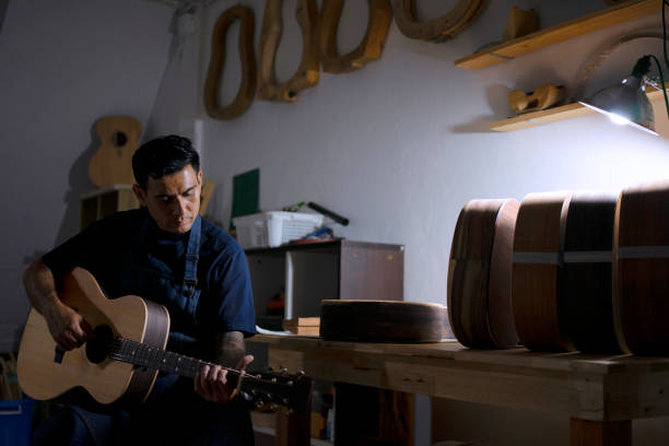 Guitar maker is making guitar at workshop. Guitar maker is making guitar at workshop. Custom guitar and small business concept. acoustic guitar tattoos stock pictures, royalty-free photos & images