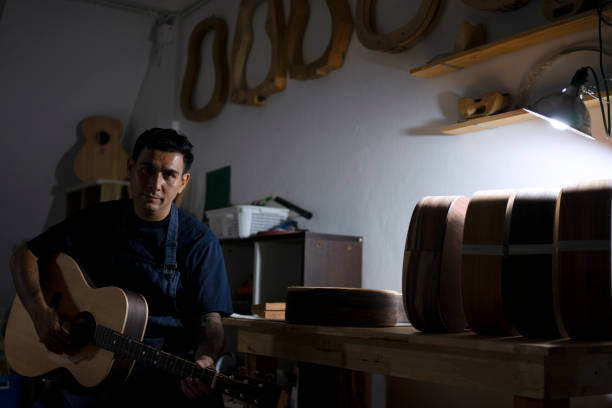 Guitar maker is making guitar at workshop. Guitar maker is making guitar at workshop. Custom guitar and small business concept. acoustic guitar tattoos stock pictures, royalty-free photos & images