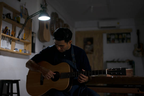 Guitar maker is making guitar at workshop. Guitar maker is making guitar at workshop. Custom guitar and small business concept. acoustic guitar tattoos stock pictures, royalty-free photos & images