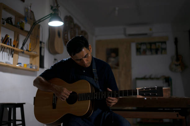 Guitar maker is making guitar at workshop. Guitar maker is making guitar at workshop. Custom guitar and small business concept. acoustic guitar tattoos stock pictures, royalty-free photos & images