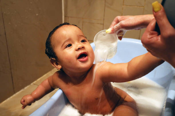 Baby boy night time bath with mother.