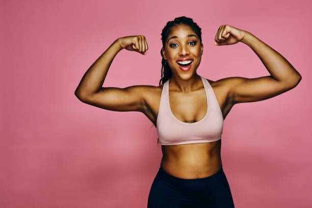 istock Woman flexing muscles in studio, laughing, 1488339485