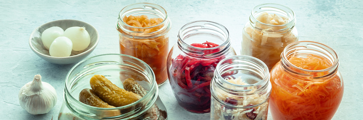 Fermented foods panorama. Homemade vegetable preserves. Sauerkraut, pickles, kimchi etc in glass jars. Healthy probiotic diet panoramic banner
