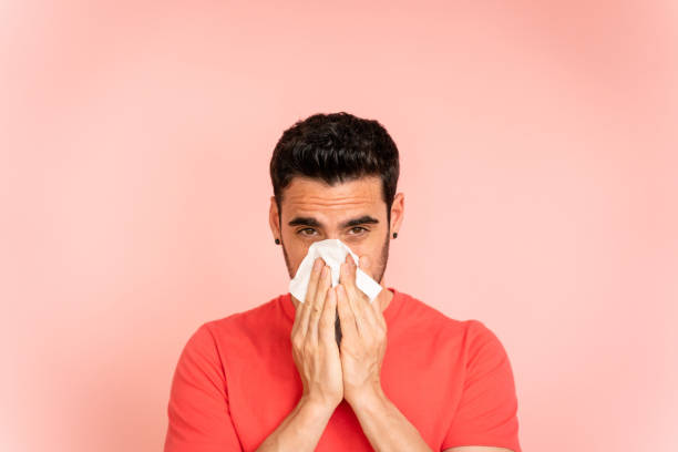 istock Man with a cold wiping his nose with tissue. 1488339878