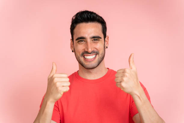 istock Smiling man with thumbs up in studio shot. 1488341147