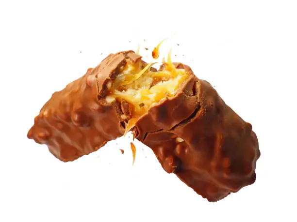 Photo of A close up of chocolate candy bar with caramel nut filling snapping in half floating in the air studio shot isolated on white background