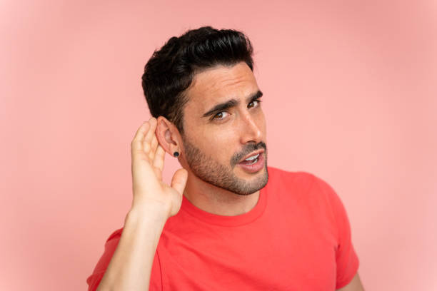istock Young man trying to hear better in a studio shot. 1488341346