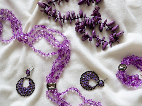 Amethyst necklace and earrings over a white background.