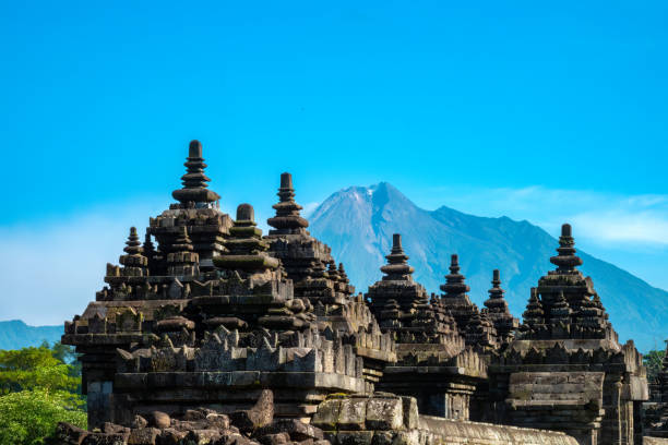 Candi Plaosan Buddhist temple with the erupting Mount Merapi Volcano in the background, Bugisan, Prambanan, Yogyakarta, Central Java, Indonesia.