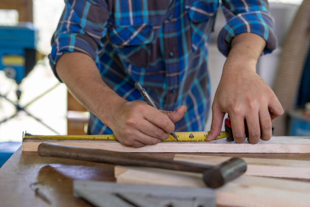 istock Carpenter is using a ruler and pencil inspection and mark point for cut. Owner a small lumber business is process for furniture production. 1488342549