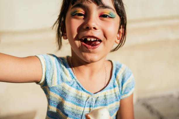 Child smiling looking at the camera with an ice cream in her hands. stock photo