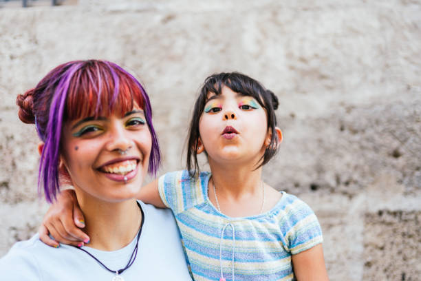 Portrait of a little girl and her mother smiling in the street stock photo