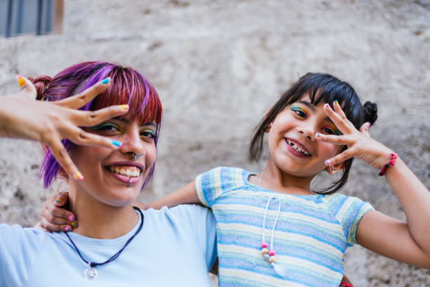 Portrait of a little girl and her mother making faces in the street stock photo