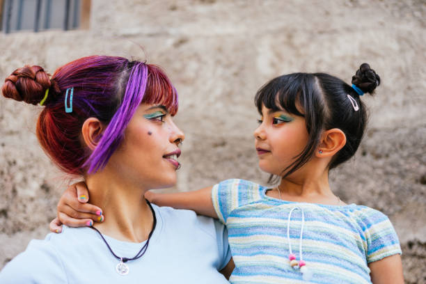 Portrait of a little girl and her mother looking each other in the street stock photo