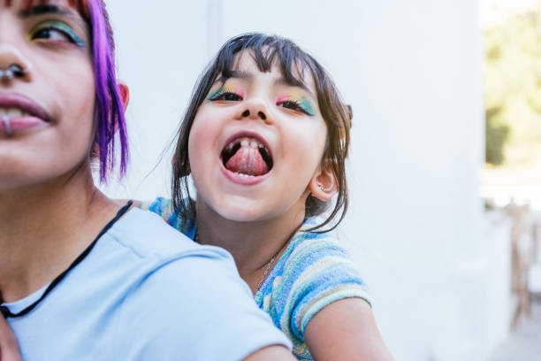 istock Girl on her mother's shoulders playing while looking at the camera 1488343321