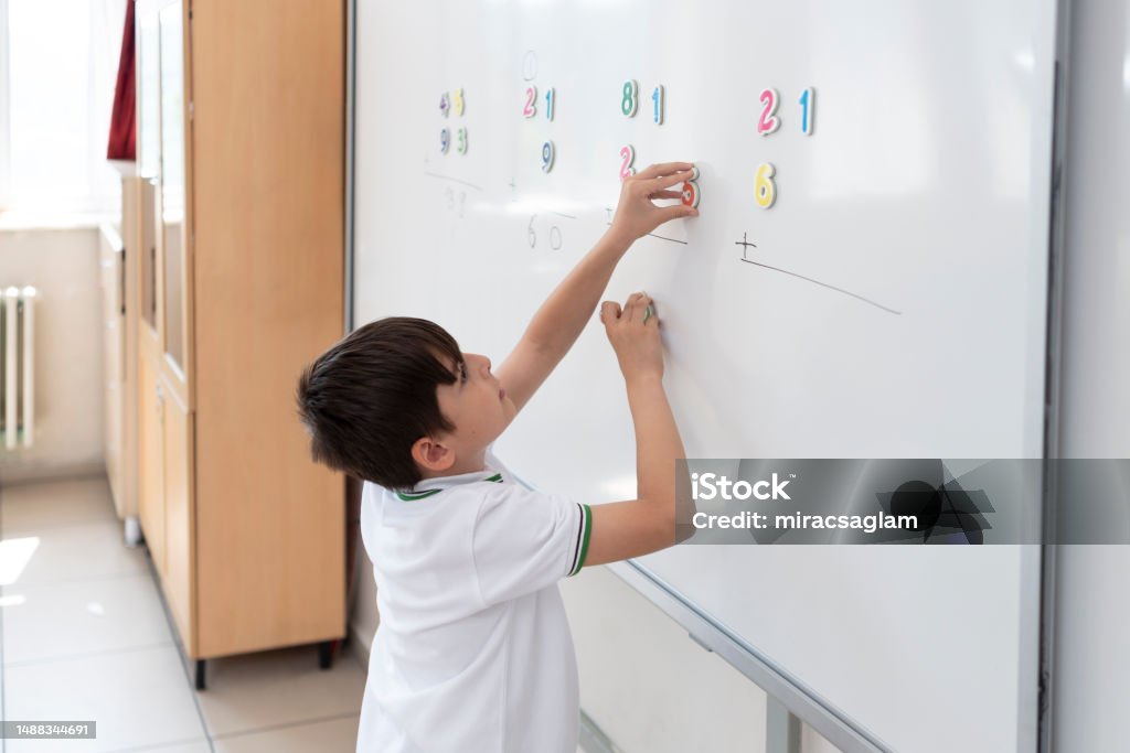 Primary School Student In Uniform Solving Math Problem With Magnetic ...