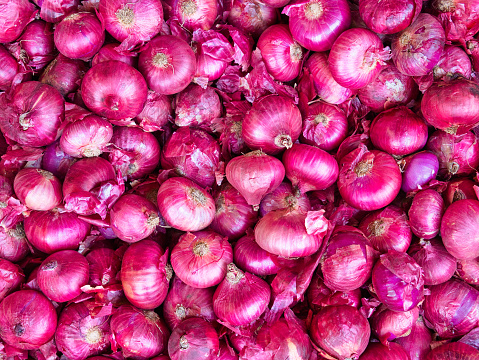 Many red onions at a wholesale vegetable market.