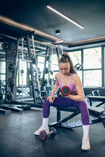 istock Young woman training in gym with dumbbells 1488346959