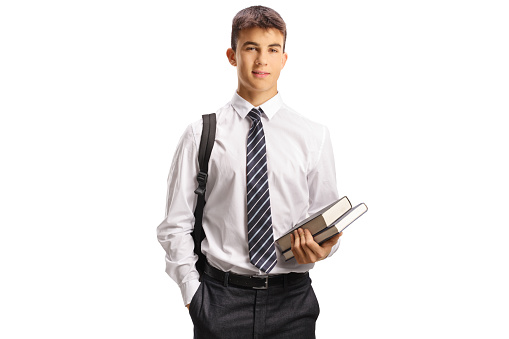 Male teen student in a school uniform holding books isolated on white background