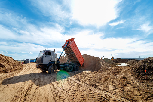 Delivery of sand to the construction site by truck with raised body.