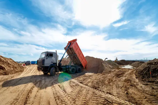 Delivery of sand to the construction site by truck with raised body.