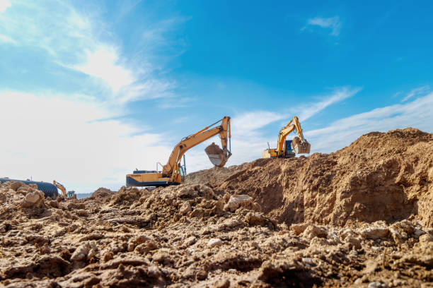 istock Two Excavator are digging soil in the construction site on sky background,with white fluffy cloud 1488348791