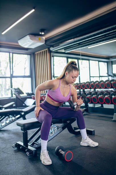 istock Young woman training in gym with dumbbells 1488349518