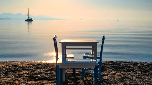 Early morning in calm sea, orange sky and authentic dinner table, calmness, serenity and meditation