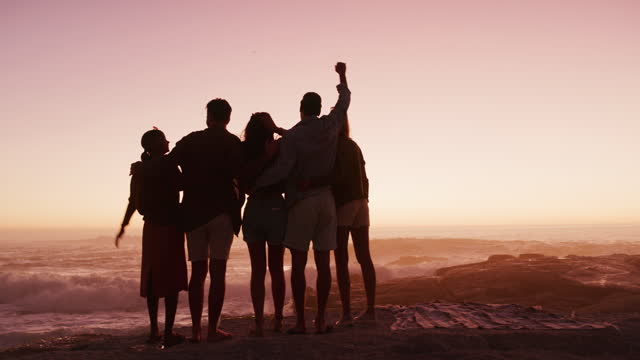 Beach, celebrate and friends silhouette by the ocean with freedom at sunset and bonding. People, holiday adventure and people by the sea water with happiness on vacation travel outdoor in group back
