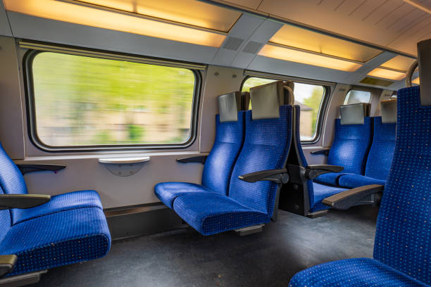 istock Passenger train with empty seats. Wide-angle long exposure, blurry green background out the window of an empty train in Switzerland, Europe, no people 1488353317